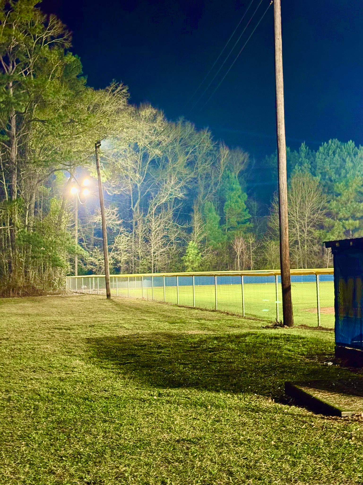 Galvanized chain link fence installed along a ball field at night