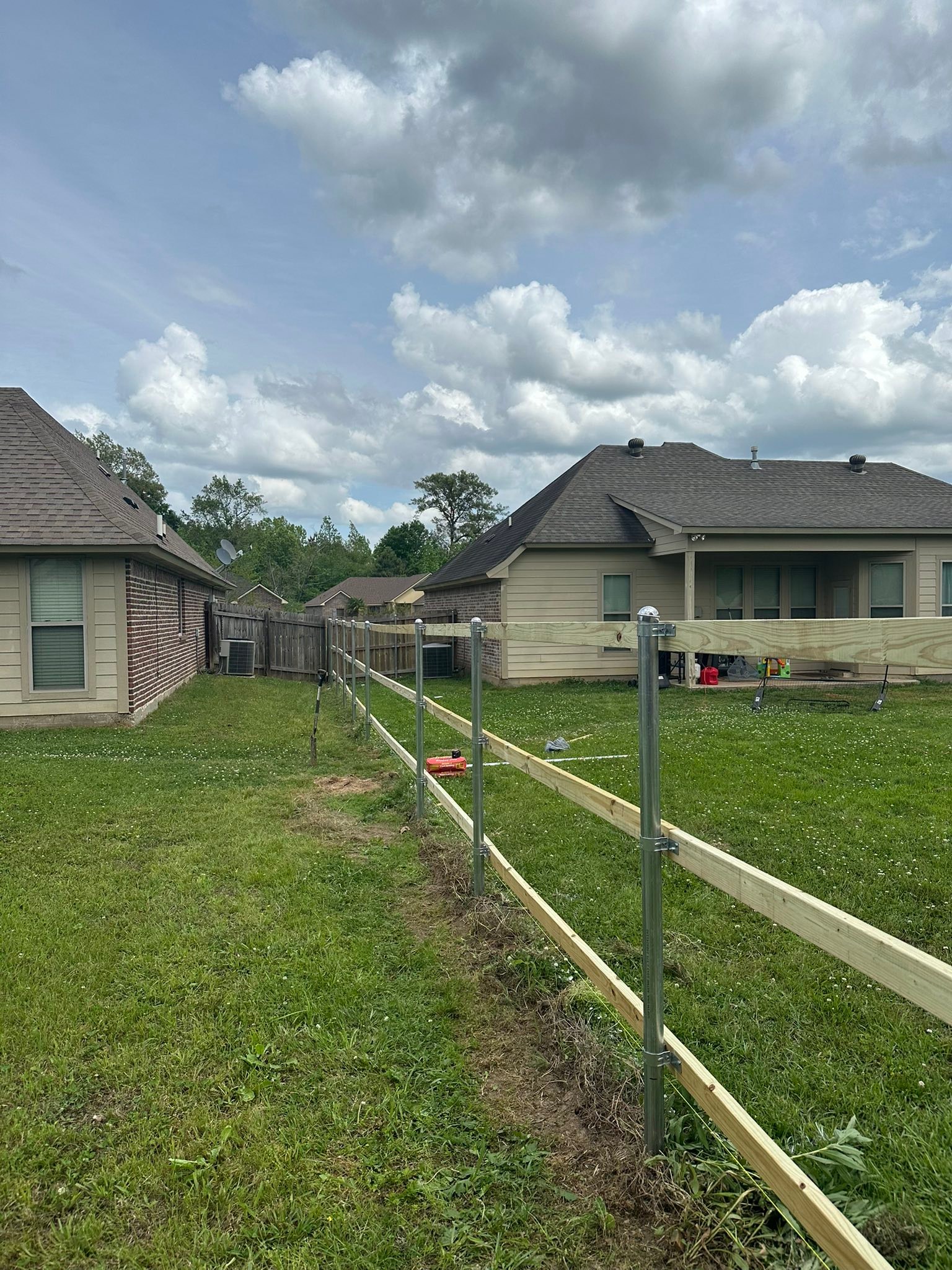 Wide estate-style fence installation across a large Louisiana property