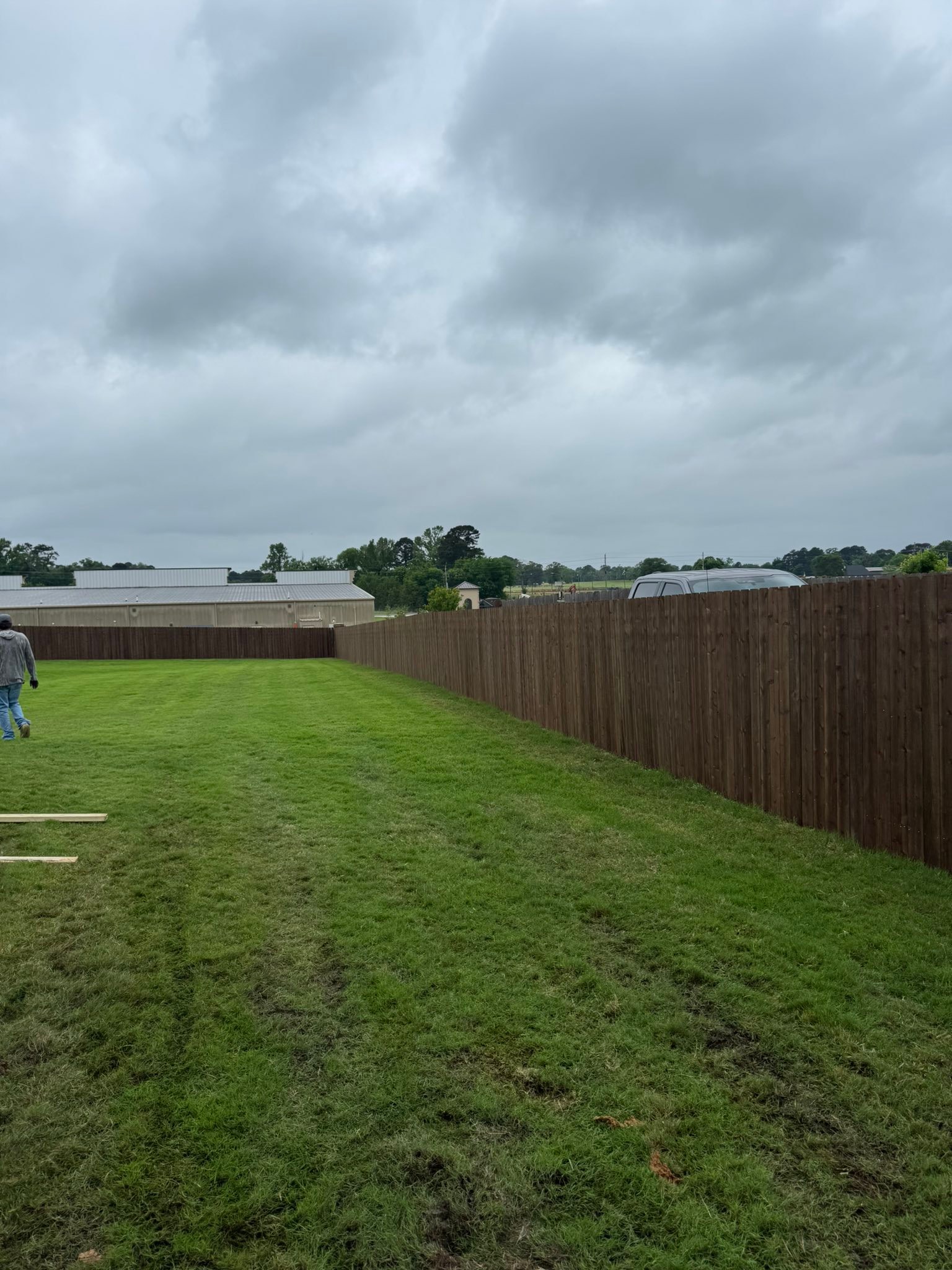 Long stained wood fence line built by Straight Line Fencing Of Louisiana in Shreveport, Louisiana